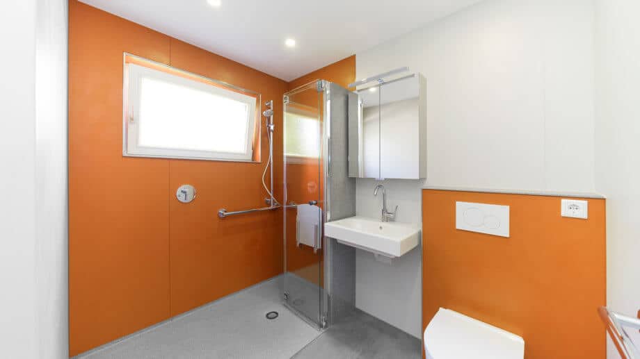 Eine begehbare Dusche von viterma ist dank Haltegriffen und Duschsitz sowie flachem Einstieg barrierefrei.